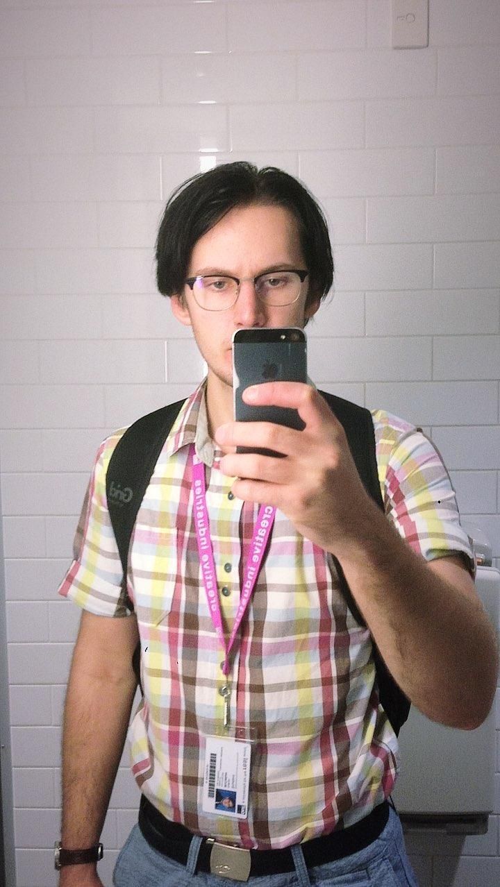 Bathroom selfie of boymode Natalie after being up all night. She is hiding her face behind the phone and exhausted.